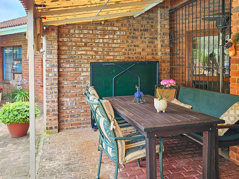 A covered outdoor patio area featuring facebrick walls and durable brick paving, providing a functional space for outdoor dining and relaxation.