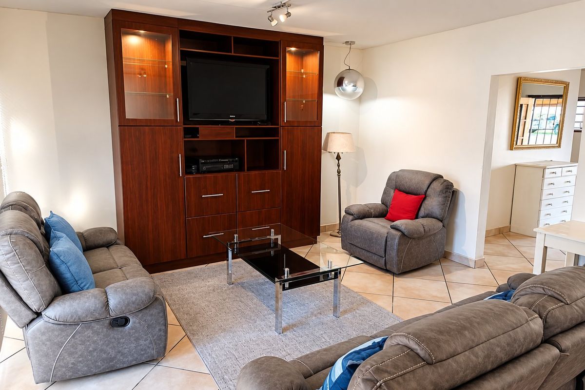 A comfortable living room featuring large built-in wooden cabinetry, ceramic tile flooring, and modern lighting fixtures, creating a functional and inviting space.