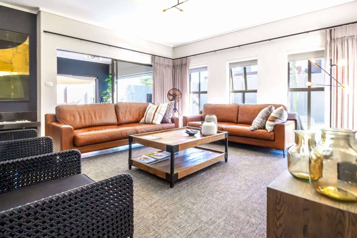 Spacious living room featuring a fireplace, large windows with curtain tracks, and sliding glass doors leading to an outdoor area.