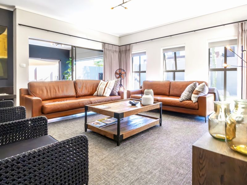 Spacious living room featuring a fireplace, large windows with curtain tracks, and sliding glass doors leading to an outdoor area.