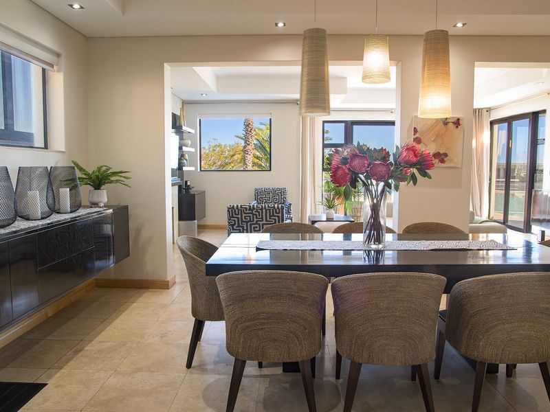 Spacious dining area featuring stone flooring, recessed ceiling lights, and large sliding glass doors that provide natural light and access to the outdoor space.