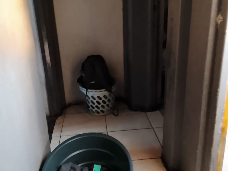 A narrow hallway area featuring tiled flooring, requiring cosmetic updates to the wall finishes and door frames.