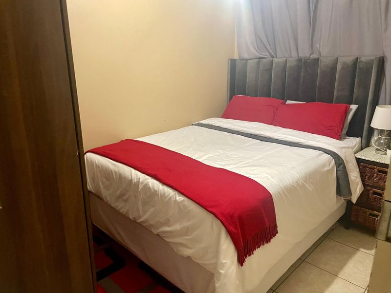 A compact bedroom featuring tiled flooring and neutral wall finishes, providing a functional sleeping space within the townhouse.