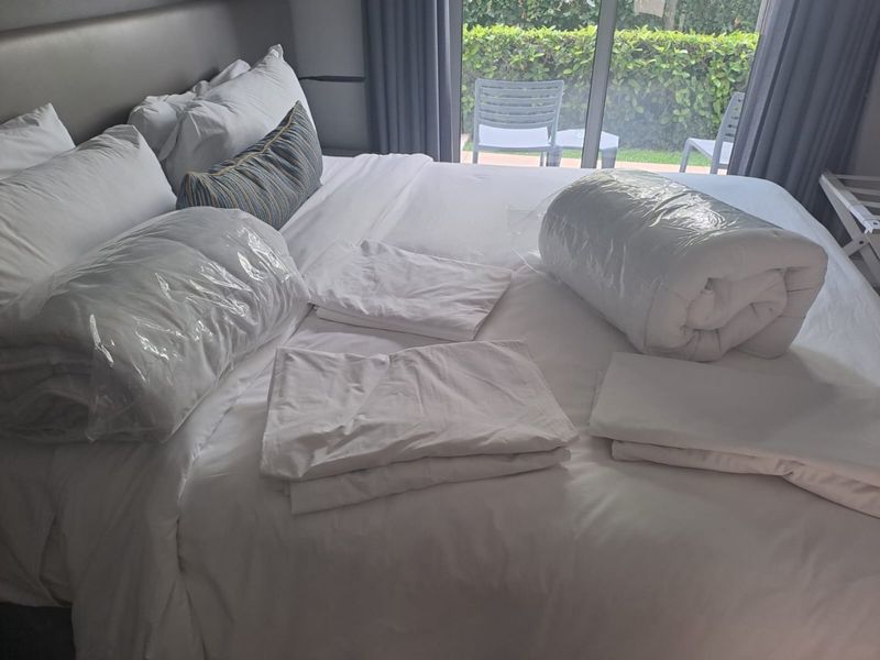 A bedroom featuring an upholstered headboard and large sliding glass doors providing access to an outdoor patio area.