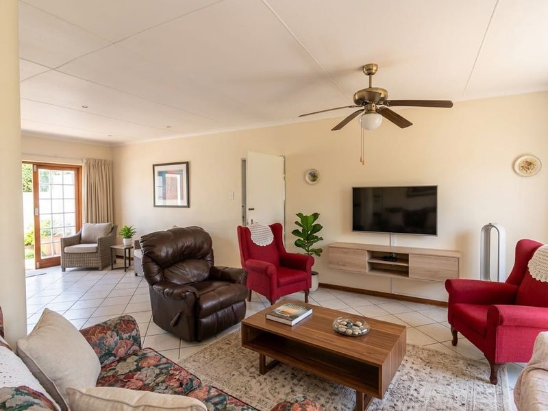 Spacious living room featuring tiled flooring, a ceiling fan, and direct access to the outdoor patio area through sliding glass doors.