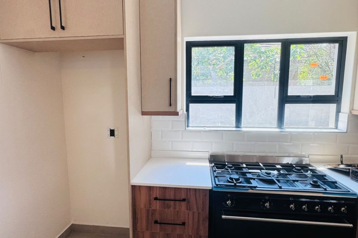 Modern kitchen featuring built-in cabinetry, a gas stove, subway tile backsplash, and tiled flooring, offering a clean and functional cooking space.