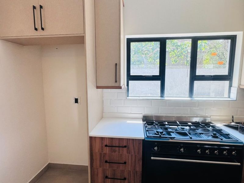 Modern kitchen featuring built-in cabinetry, a gas stove, subway tile backsplash, and tiled flooring, offering a clean and functional cooking space.
