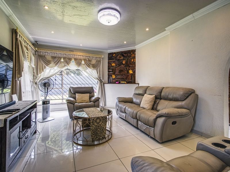 A living room featuring polished tiled floors, recessed lighting, and a decorative stone wall accent, providing a comfortable and functional living space.
