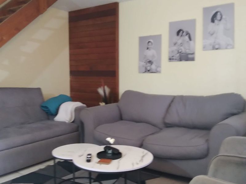 A living room area featuring a wooden staircase and decorative timber wall paneling, providing a warm and textured architectural element to the space.