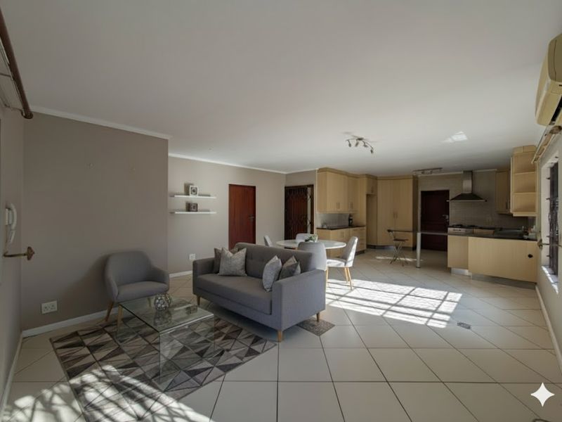 Spacious open-plan living area featuring tiled flooring, a modern kitchen with built-in cabinetry, and an integrated air conditioning unit.