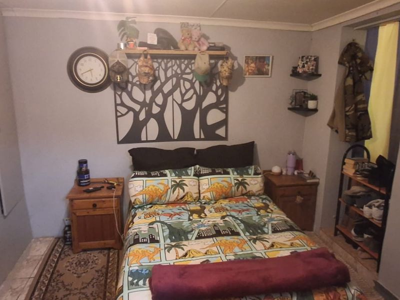 A functional bedroom featuring built-in cupboards and tiled flooring, offering a practical layout for comfortable living.