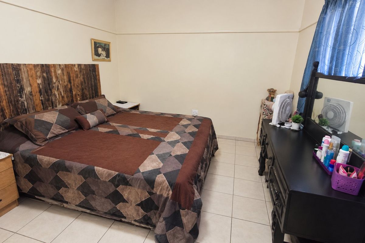 A functional bedroom featuring tiled flooring and a classic picture rail, offering a neutral base for personalization.