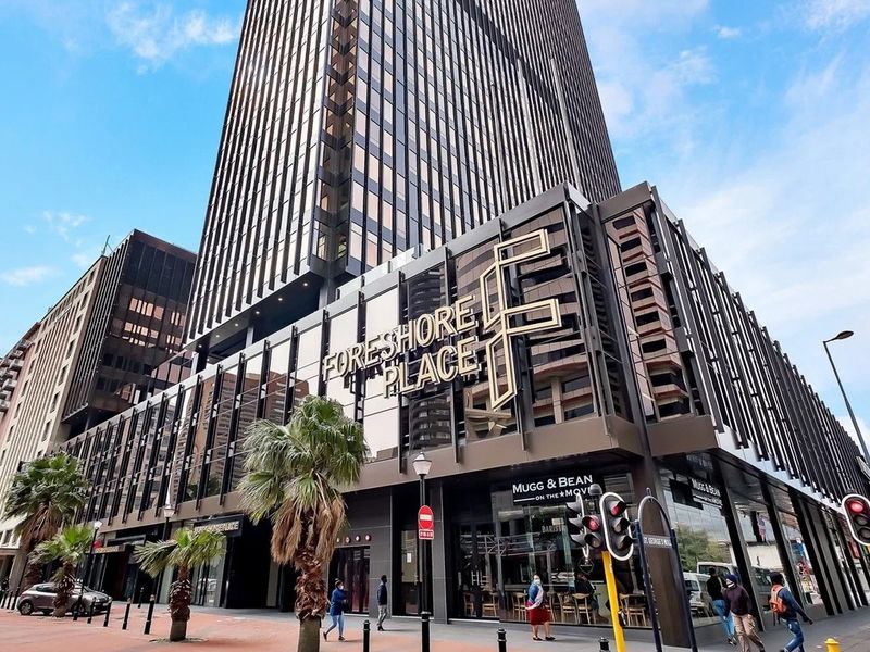 Exterior view of Foreshore Place, a prominent high-rise commercial building featuring modern glass facade architecture and ground-level retail frontage.