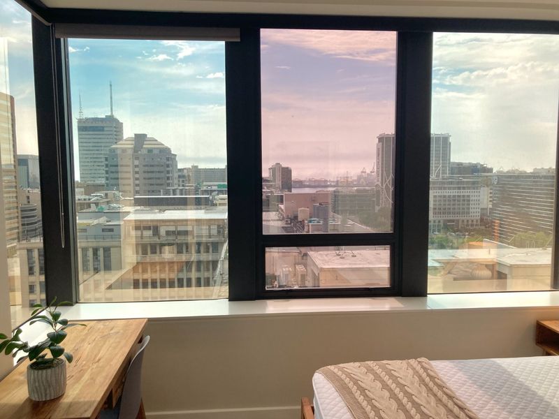 A bright interior space featuring large floor-to-ceiling windows that offer an expansive urban city view.