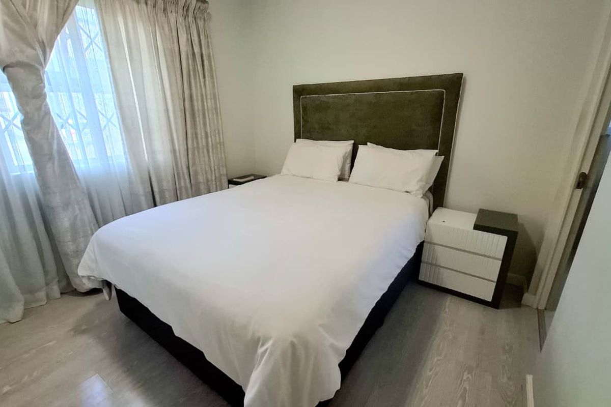 A well-maintained bedroom featuring light-toned laminate flooring and neutral wall finishes, providing a clean and comfortable living space.