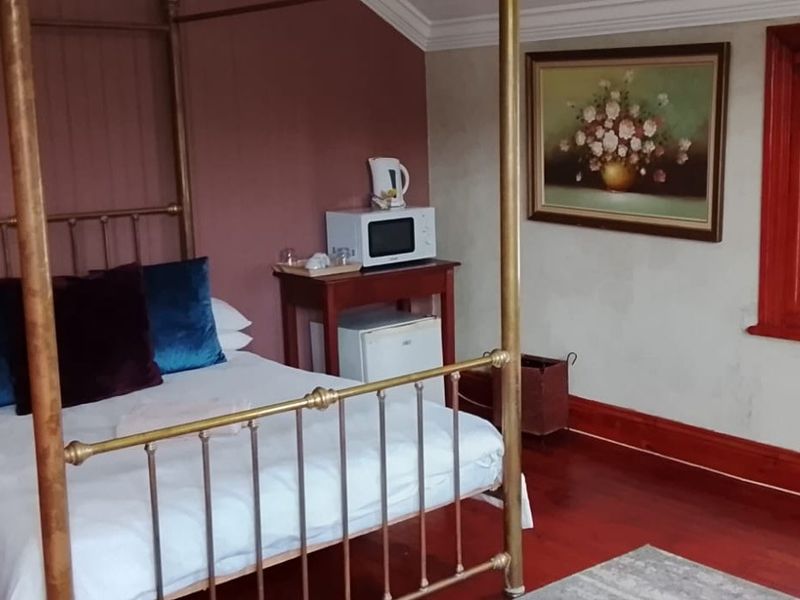 A bedroom featuring hardwood flooring, coved ceilings, and timber window frames, offering a classic aesthetic with potential for modern updates.