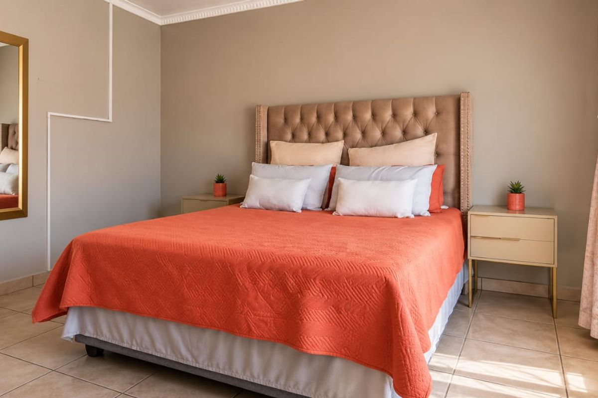 A well-maintained bedroom featuring neutral wall tones, tiled flooring, and decorative coving, providing a clean and comfortable living space.