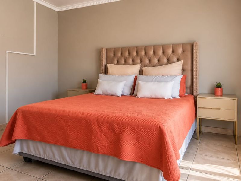 A well-maintained bedroom featuring neutral wall tones, tiled flooring, and decorative coving, providing a clean and comfortable living space.