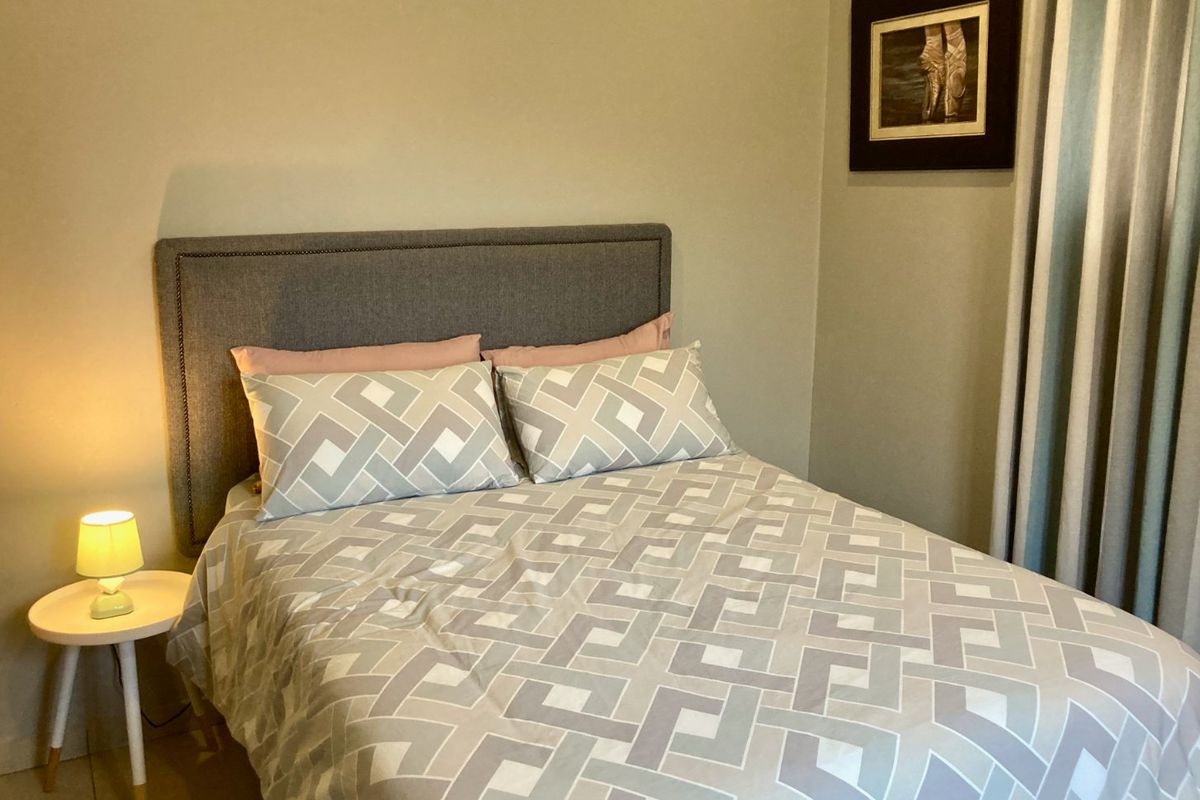 A cozy bedroom featuring neutral wall tones and a functional layout, suitable for a comfortable sleeping space.