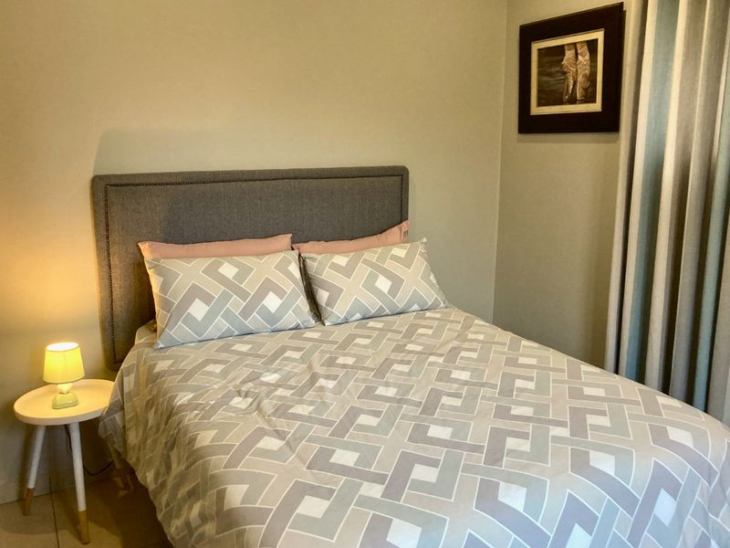 A cozy bedroom featuring neutral wall tones and a functional layout, suitable for a comfortable sleeping space.
