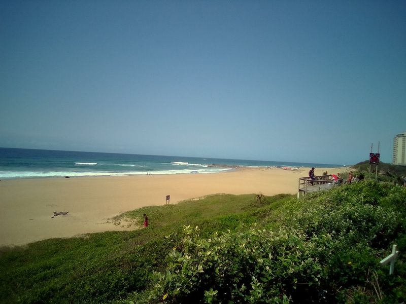 A scenic view of the coastline and beach, showcasing the natural landscape and proximity to the ocean.