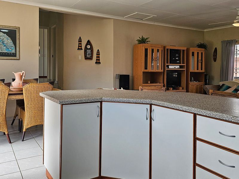 Open plan living and dining area featuring a central kitchen island with laminate countertops and tiled flooring throughout.
