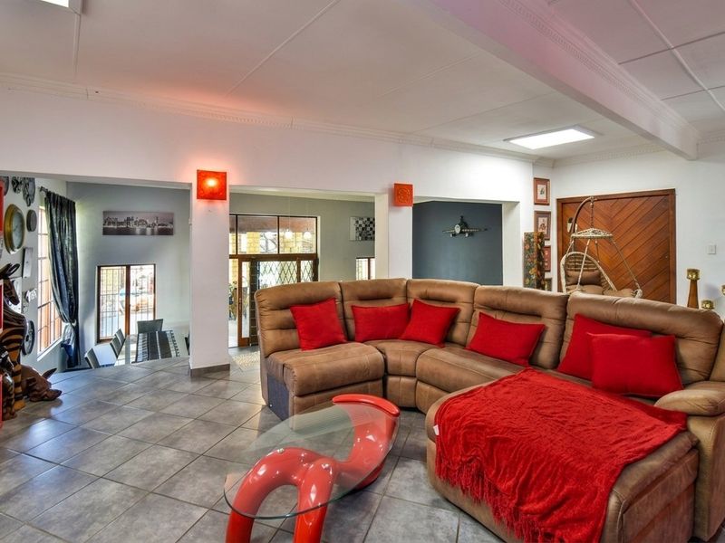 Spacious open-plan living area featuring tiled flooring, recessed lighting, and a skylight, providing a bright and functional space for relaxation.