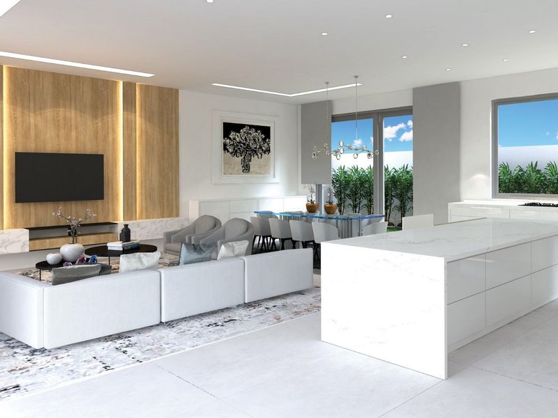 Spacious open-plan living area featuring a modern kitchen with a large island, wood-accented media wall, and seamless flow to the outdoor space.
