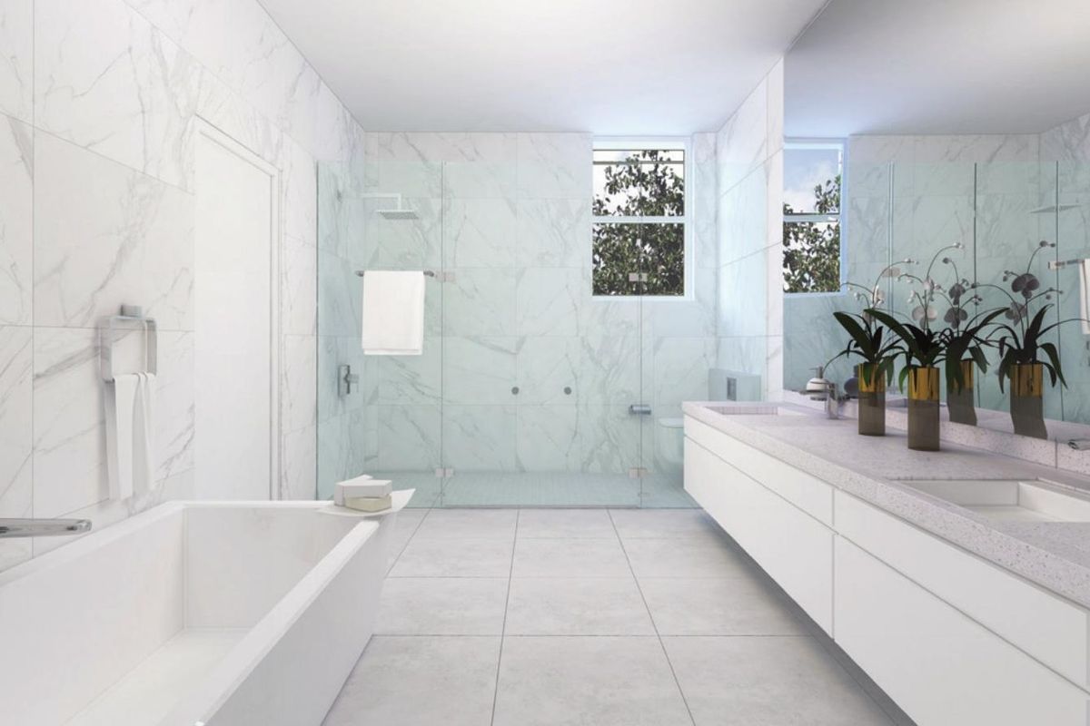 Modern, spacious bathroom featuring marble wall tiling, a large walk-in shower with glass enclosure, a double vanity, and a built-in bathtub.
