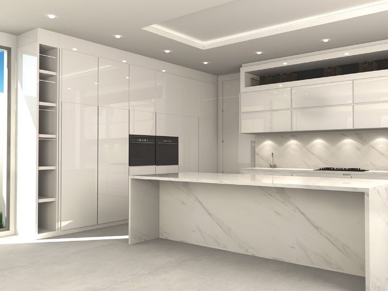Modern, high-end kitchen featuring sleek white cabinetry, a marble-topped island, integrated appliances, and recessed lighting, creating a clean and sophisticated culinary space.