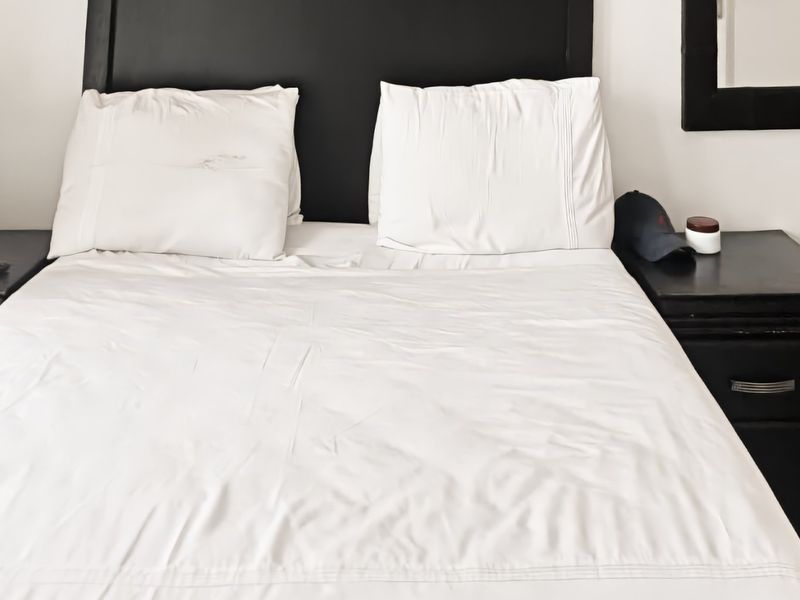 A bedroom featuring a built-in headboard and neutral wall finishes.