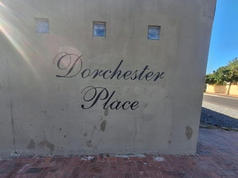 Entrance signage wall for Dorchester Place featuring brick paving and decorative glass block inserts.