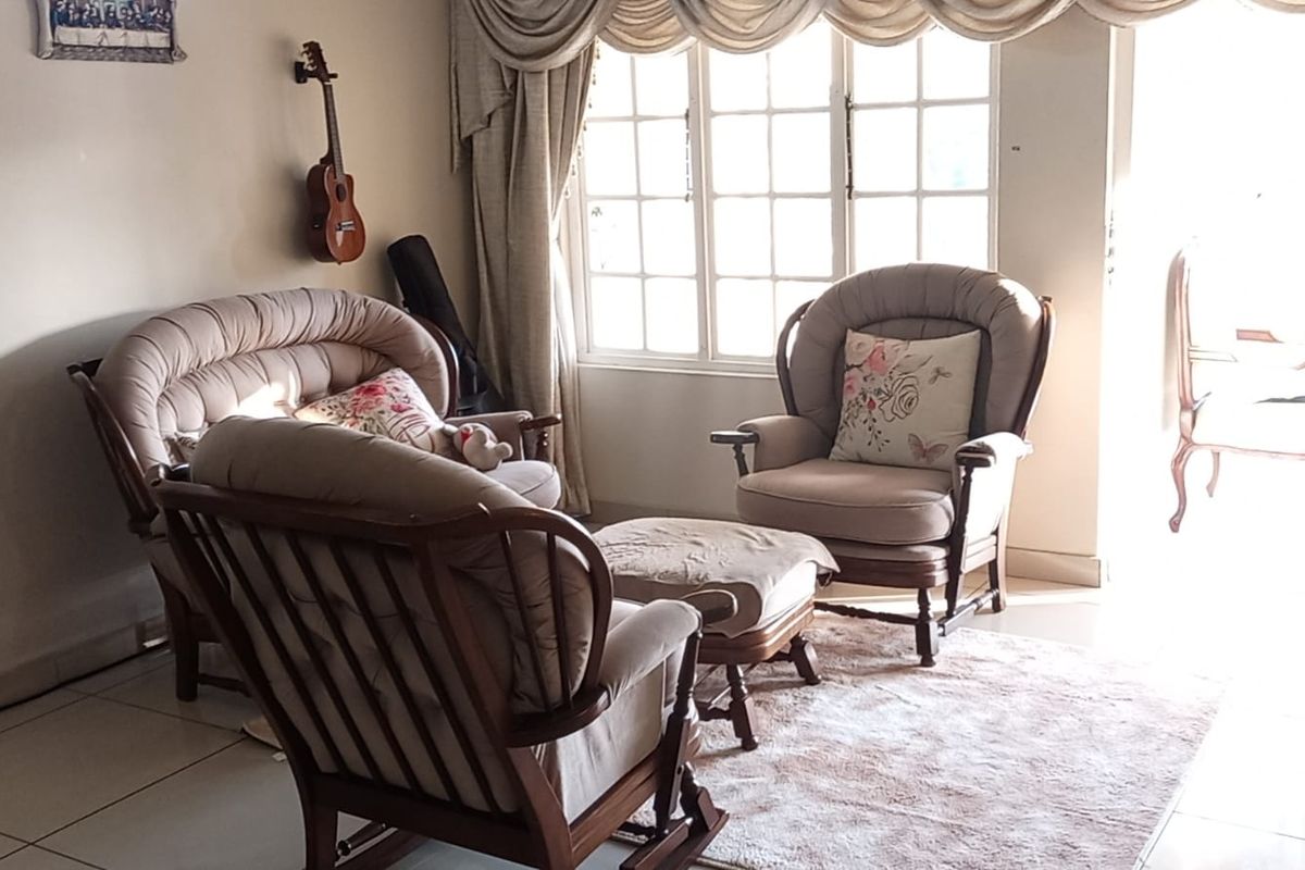 A comfortable living room area featuring large multi-pane windows that allow for natural light and tiled flooring throughout.