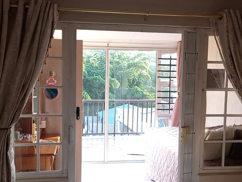 Bedroom featuring classic french doors opening onto a private balcony with exterior views.
