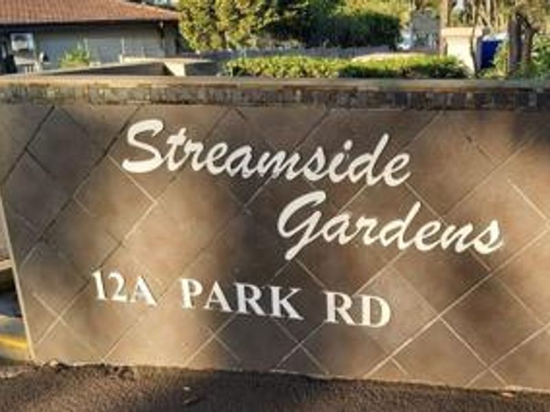 A clear view of the Streamside Gardens complex entrance signage and masonry boundary wall located at 12A Park Road.
