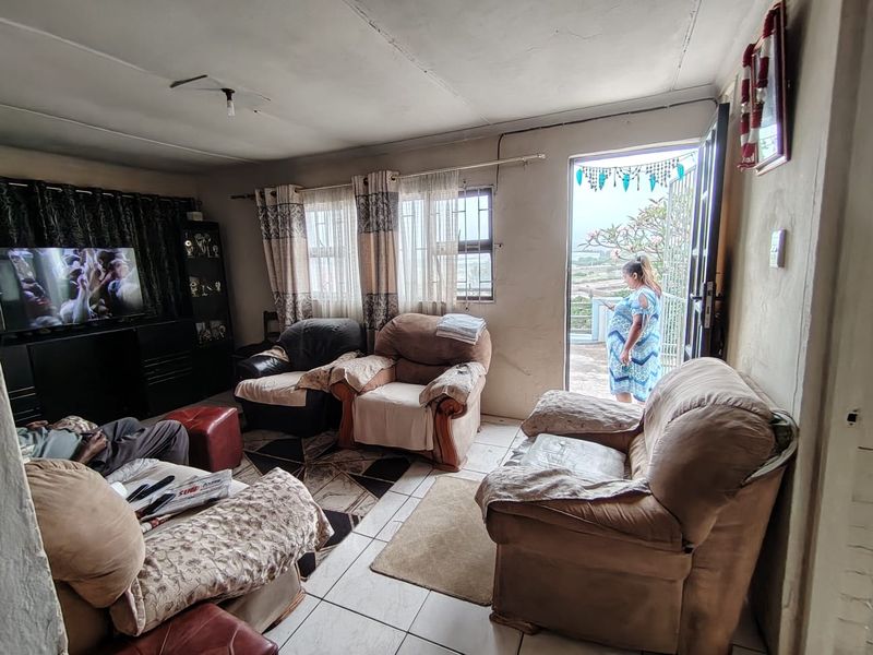 A living room featuring tiled flooring and direct access to an outdoor area, requiring cosmetic updates to the walls and ceiling.
