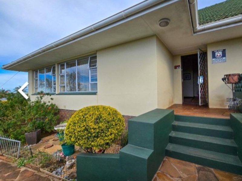 Front entrance of the house featuring concrete steps, security gate, and aluminium window frames with a tiled roof.