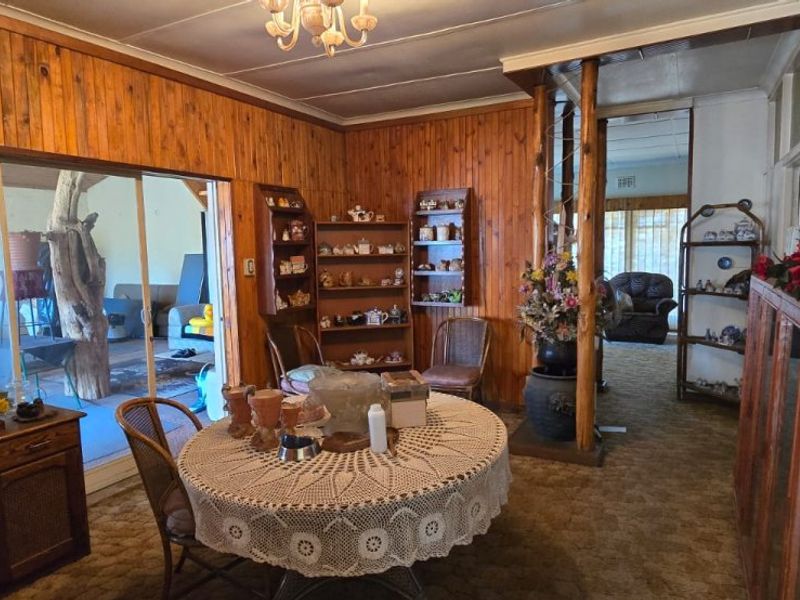 Living room featuring wood paneling, built-in shelving, and sliding glass doors leading to an outdoor area, with dated finishes throughout.