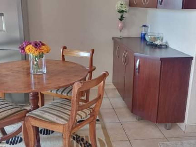A dining area featuring tiled flooring and built-in wooden cabinetry, providing a functional space adjacent to the kitchen area.