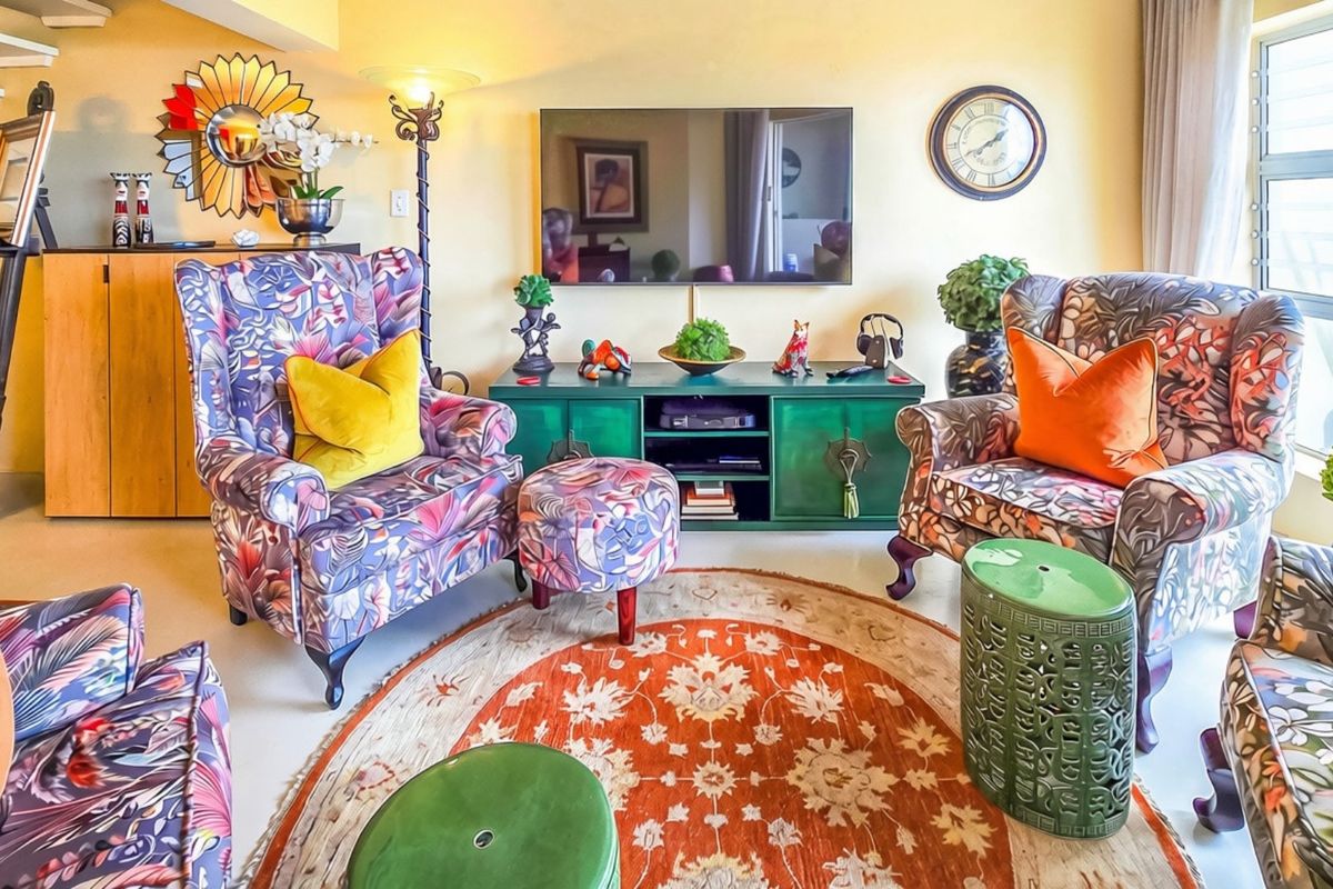 A vibrant living room featuring louvered windows and an adjacent staircase, offering a cozy and well-lit space for relaxation.