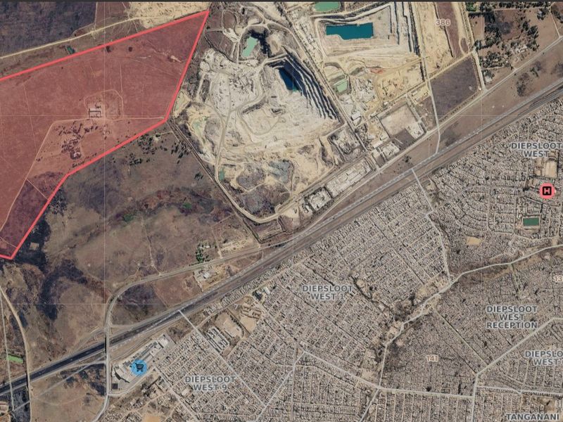 Aerial view of a large, undeveloped residential land parcel highlighted in red, situated near existing urban infrastructure and major transport routes.