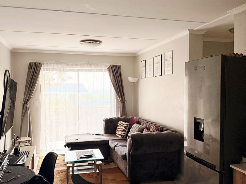 Open plan living area featuring tiled flooring and a sliding glass door providing natural light and access to the exterior.