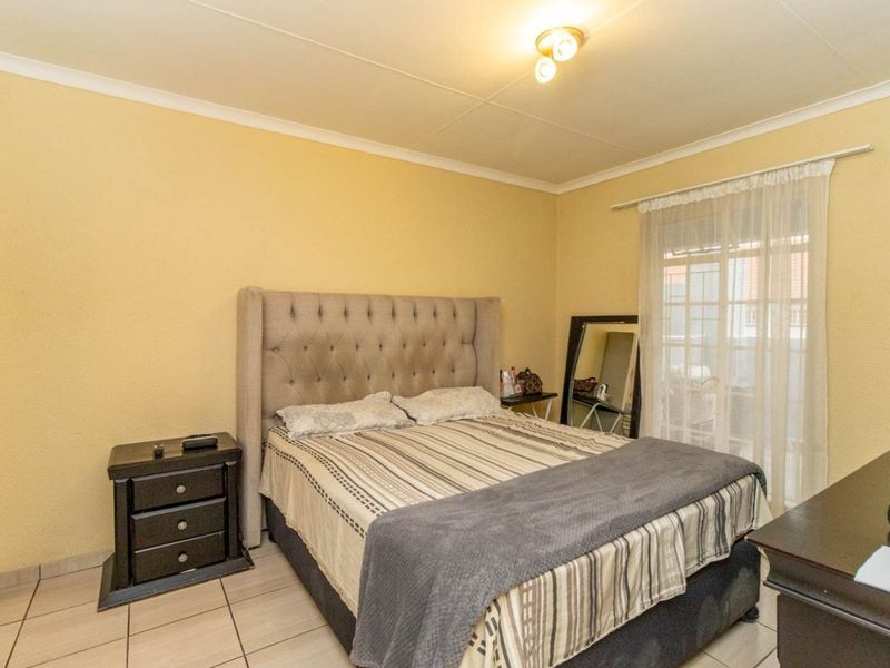 A bedroom featuring tiled flooring and a sliding glass door providing access to an outdoor area.