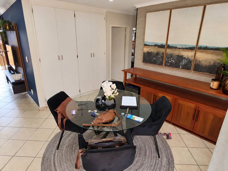 Open plan living area featuring tiled flooring, built-in storage cupboards, and custom cabinetry, providing a functional and well-maintained space.