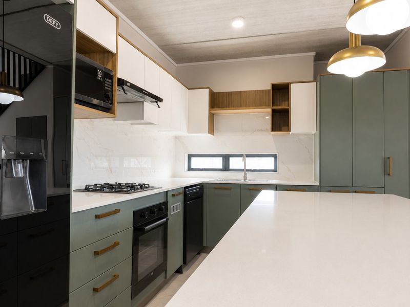 Modern kitchen featuring high-end cabinetry, stone countertops, integrated appliances, and a central island, finished with contemporary lighting and clean architectural lines.