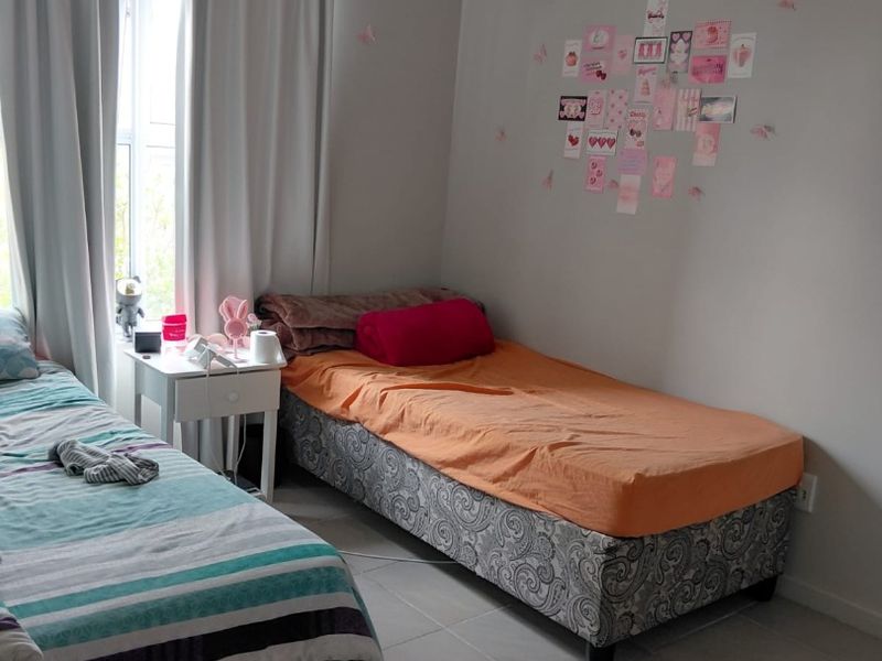 A functional bedroom featuring tiled flooring and neutral wall finishes, providing a clean and simple space for rest.