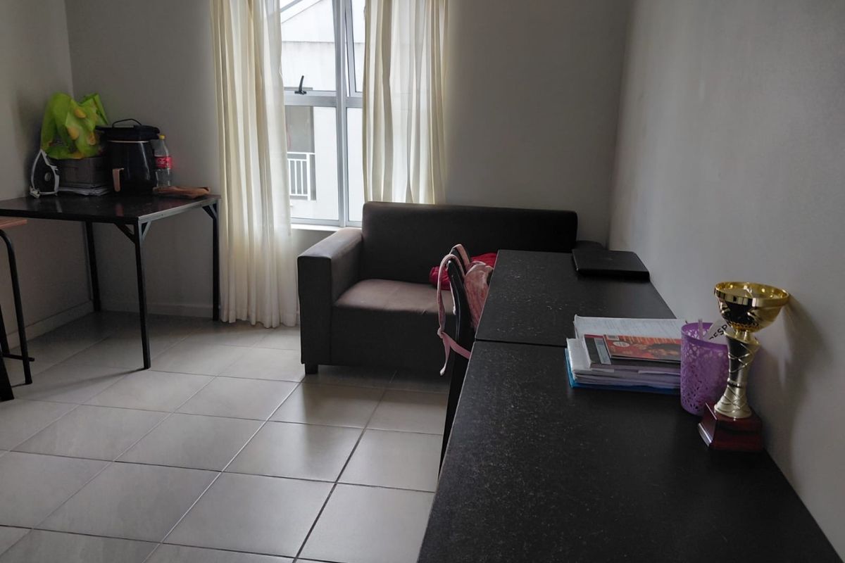 A functional living area featuring neutral tiled flooring and a large window, providing a blank canvas for interior design updates.