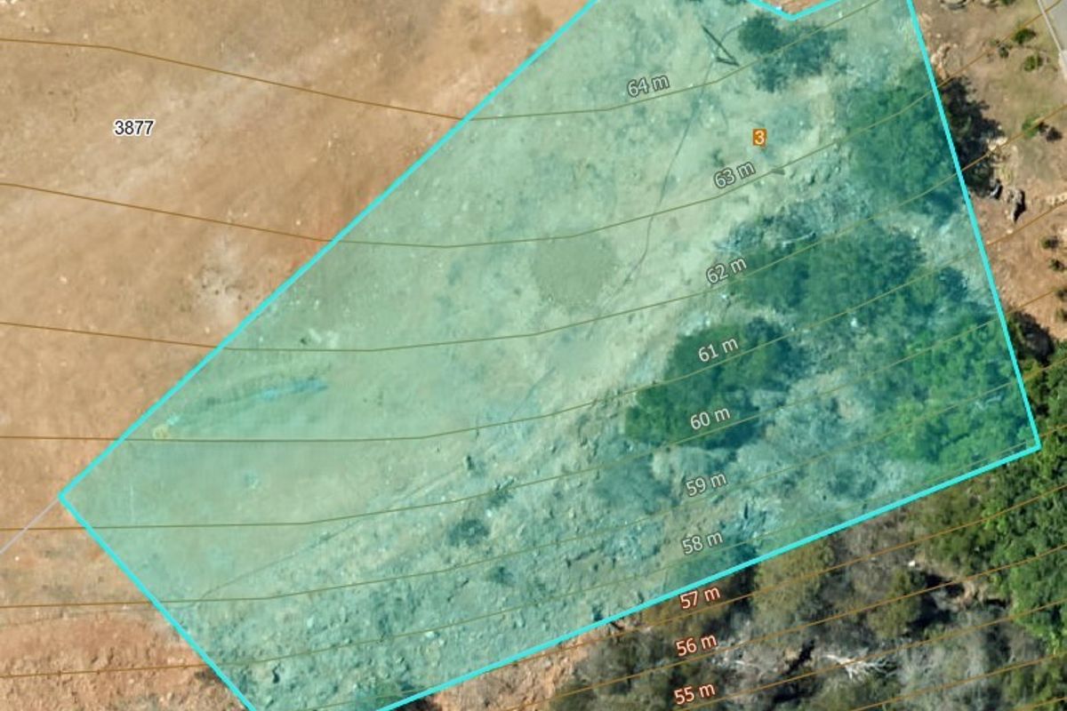Aerial view of a vacant residential plot featuring topographical contour lines indicating the slope and layout of the land.