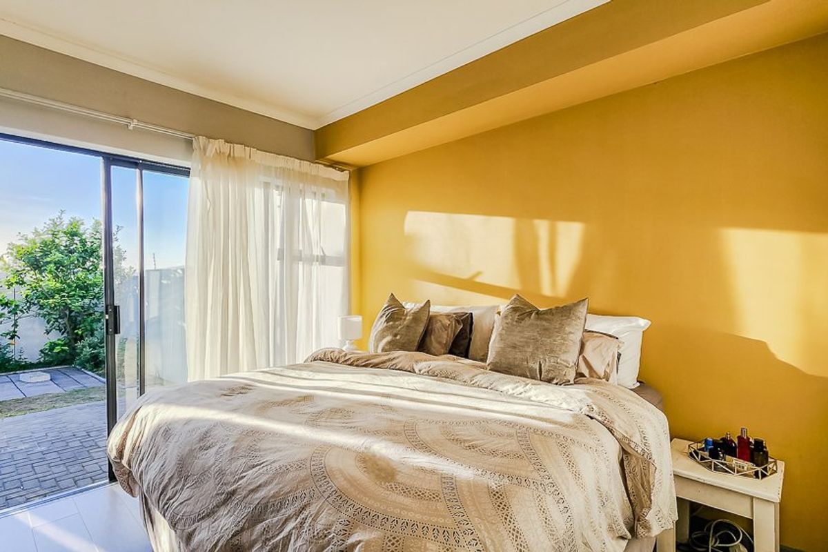 Bright bedroom featuring tiled flooring and a large sliding glass door providing direct access to the outdoor patio area.