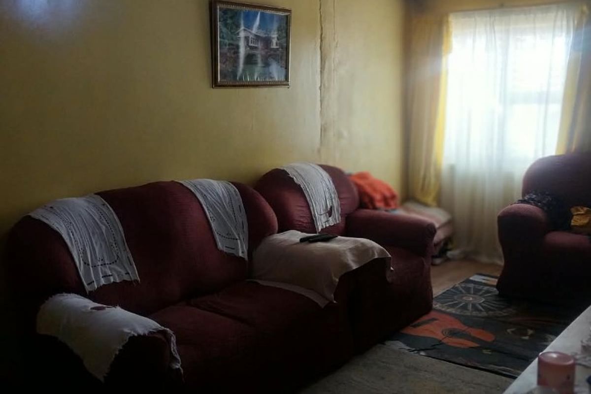A living room featuring a timber ceiling and visible wall cracks, requiring cosmetic updates to improve the overall condition and aesthetic appeal.